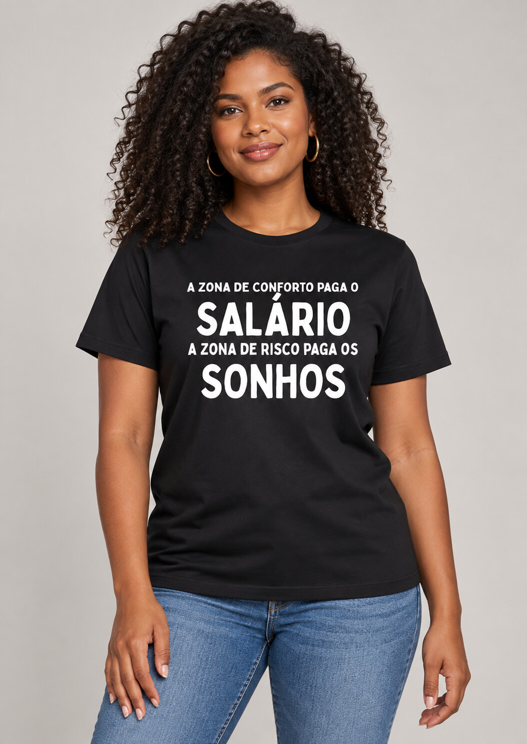 Mockup da Coleção Joyce Azevedo: camiseta preta com a frase A zona de conforto paga o salário. A zona de risco paga os sonhos.